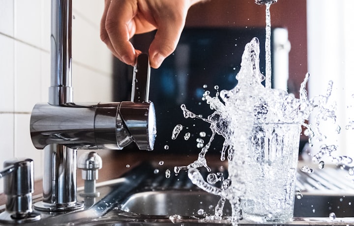 Kitchen faucet running water into a glass